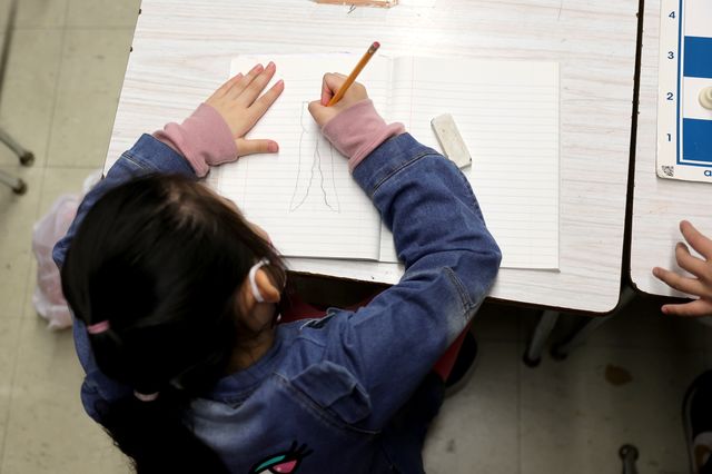 A student draws on a piece of paper at Yung Wing School P.S. 124 in Manhattan.